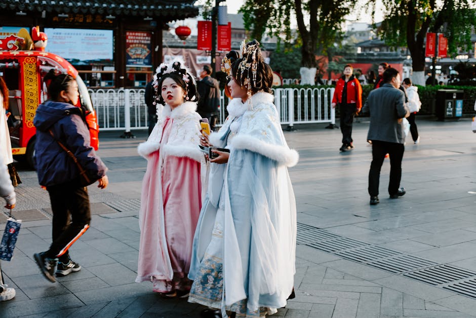 People in traditional attire stroll through a vibrant Nanjing street in autumn.