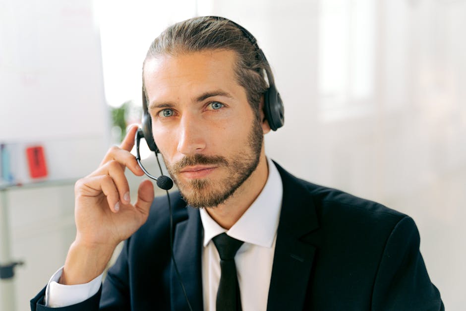 Close-up portrait of a professional male customer service representative wearing a headset in an office.